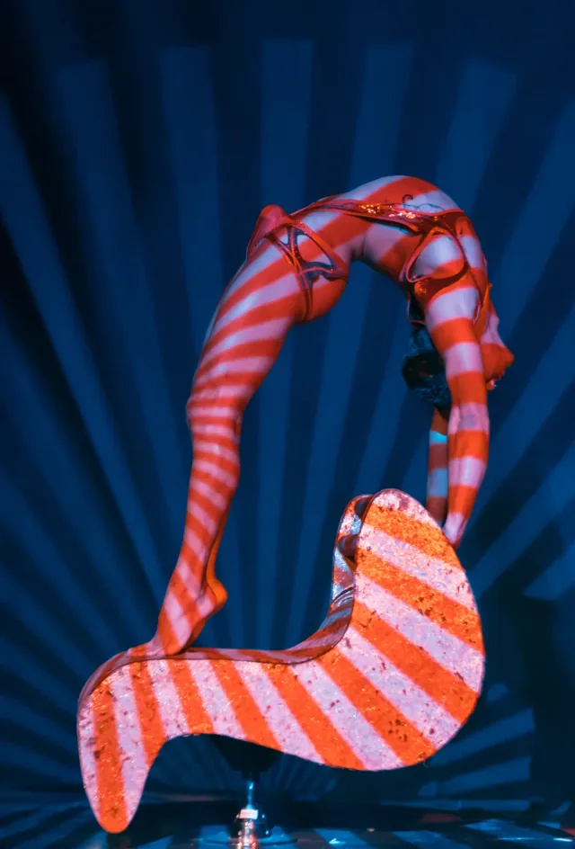 Contortionist on striped sculptural prop