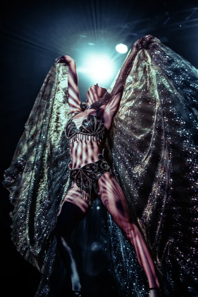 Burlesque showgirl with starlit cape wings
